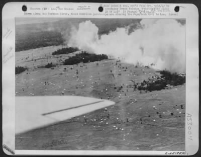 Consolidated > Shown along the Markham River, these American paratroops are closing the Japs back door to Lae. Some have landed but others are still in the air. Note the planes, also the smokescreen which conceals the action from the Japs across the river.