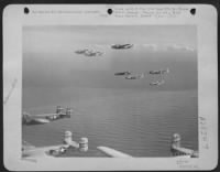Over quiet Mediterranean waters these 12th AF North American B-25 Mitchell bombers fly toward their buses on Corsica after bombs carried in these same aircraft and wrecked a German-used railroad bridge at Sacile, 40 miles north of Vernice, Italy on - Page 1