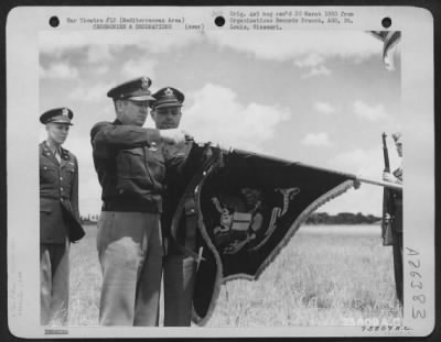 Consolidated > The Presidential Unit Citation is pinned on the unit flag of the 17th Bomb Group during a ceremony at an airfield somewhere in the Mediterranean Area.