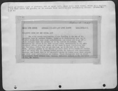 Thumbnail for Consolidated > Dozens of heavy bombs float lazily down on Japanese installations at Lae, New Guinea. Spots in middle right of picture, and in upper left, show still more bombs, which will explode a few feet above the ground, or on contact with terrific and