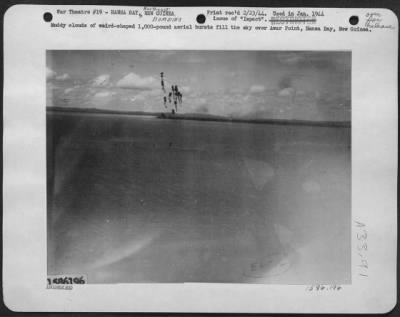 Thumbnail for Consolidated > Muddy clouds of weird-shaped 1,000-pound aerial bursts fill the sky over Awar Point, Hansa Bay, New Guinea.