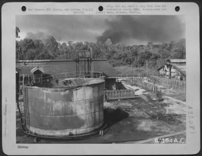 Thumbnail for Consolidated > Most of the tanks "blew their tops"; some however, merely collapsed. The variation might possibly have been caused by oil of different volatility. Seria, New Guinea, 5 July 1945.