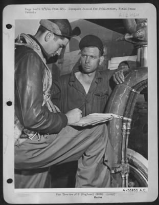 Ground > ENGLAND-T/Sgt Charles E. Edwards, 24, Cordele, Ga., flight engineer on "Flying Crusader" checks perofrmance of plane ofllowing mission with M/Sgt John Coltran. The two have a conference every time the plane lands, and usually Edwards gives good