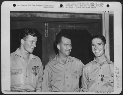 Consolidated > "ACES" DECORATED IN NEW GUINEA: Brig. General Paul B. Wurtsmith (center), San Antonio, Texas, Commander of Fighter Squadrons in New Guinea, at night presentation ceremony when he decorated 1st Lt. Kenneth C. Sparks (left) of Blackwell