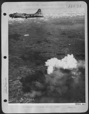Consolidated > White boiling smoke surges skyward from a medium tank factory at Nurnberg, Germany, about 90 miles north of Munich, as one of the attacking B-17 Flying Fortresses of the 8th AF passes overhead, 10 Sept 44.