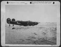 Bogged down in the shifting sands of the Adriatic Sea in eastern Italy, this Consolidated B-24 Liberators presents a sad picture, after it was forced to crash-land because of damage received by enemy fire while on a mission over northern Italy. An 11 - Page 1