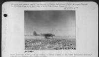 North American B-25 taxies up runway, as other planes of the "Over 500-plane mission," come in for landing in a cloud of dust. - Page 1