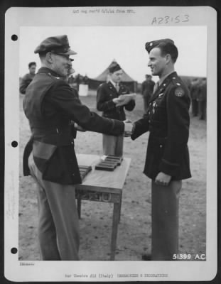 Thumbnail for Consolidated > With the Distinguished Flying Cross pinned to his tunic, Major Donald L. Perry, 5135 W. 18th St., Hawthorne, Calif., is shown being congratulated by Col. Charles W. Lawrence, Commanding Officer of an AAF Wing, who made the presentation to the P-38