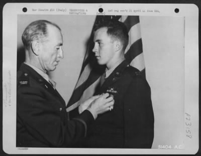 Consolidated > Capt. John J. Brunasky, son of A.F. Brunasky, 1600 Morningside Ave., Pittsburgh, Pa. is congratulated by Col. John W. Monahan, Chief of Staff of Maj. General John F. Cannon's 12th AF, after receiving the Distinguished Flying Cross for his exploits as