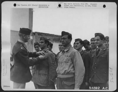 Consolidated > Lt. Col. Joseph G. Russell, of San Antonio, Texas, Commanding Officer of a Liberator Bomber Group, pins the soldiers Medal on Sgt. Major Santo Tedono, an Italian soldier who was born in White plains, N.Y. With Sgt. Major Nicola Surdo, (standing at