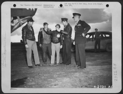Consolidated > Maj. Gen. Nathan F. Twining, Commanding General of the 15th Air Force, extreme right, pauses on an inspection tour of this Consolidated B-24 Liberator base to examine the nose of a Liberator bomber. On the left is Brig. Gen. Carlyle H. Ridenour