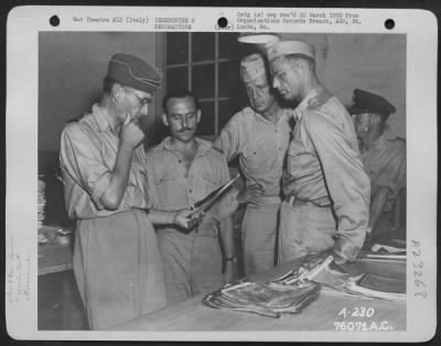 Thumbnail for Consolidated > Air Marshall Sir Arthur Tedder (Extreme Left) Studies Aerial Photogrpahs During His Tour Of Inspection At A 90Th Photographic Reconn Wing Base Somewhere In Italy As Brig. Gen. Patrick W. Timberlake (Third From Left) Looks On.