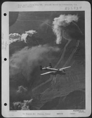 Thumbnail for Consolidated > With a trail of fire and smoke behind it, this North American B-25 Mitchell of the 12th Air Force heads for its home base after smashing at the Motti Di Livenza Bridge, 30 miles northeast of Venice, on December 11, 1944.