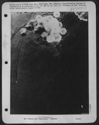 Thumbnail for Consolidated > Bomb bursts from Northwest African Air Forces Boeing B-17 Flying Fortresses completely blanket Italian heavy cruiser and its protecting torpedo boom in La Maddalena harbor.