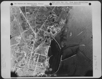 Thumbnail for Consolidated > Bombs dropped by 15th Air Force planes of the 97th Bomb Group, 340th Bomb Squadron, burst on enemy installations at Marsala Port, Sicily. 11 May 1943.