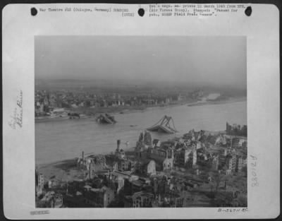 Consolidated > General view of damage inflicted upon Cologne by repeatedly heavy Allied air assaults is recorded in this photo taken by a 9th AF photographer advancing along with Gen. Hodges First Army. One of the knocked out bridges wallow in the Rhine.