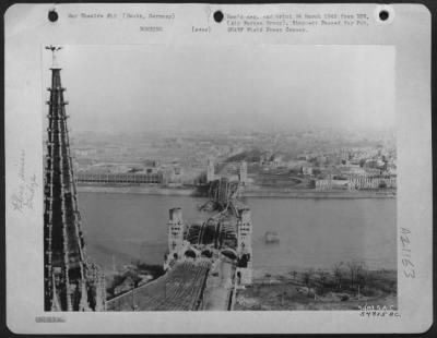 Consolidated > View of Deutz, Germany, showing the collapsed Hohenzellern bridge over the Rhine River photographed by a combat cameraman of the 9th Air Force who accompanied the first U.S. troops to enter the city. The picture was taken from the tower of the