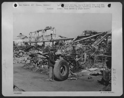 Consolidated > One Old Used Tire Found In The Rubble That Remains Of The Deutsch Dunlop Ag Tire And Rubber Factroy At Hanau After It Was Hit By Raf And Us 8Th Af Heavy Bombers.  An American Officer Is Looking At The Tire As The Second Most Important Rubber Plant On The