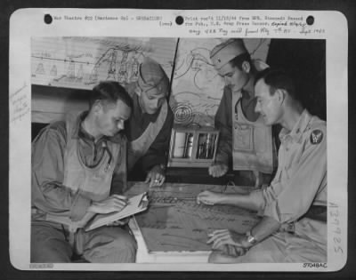 Consolidated > Marianas Group -- Showing 7Th Aaf Bomber Crewmen What To Expect On Their Way To The Target, Lt. William Troutman, Elizabeth, Pa., Oceanographer, And Forecaster, Goes Over Maps And Charts In An Advanced 'Weather Central' Tent. Map In The Foreground Shows L