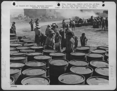 Consolidated > Japanese Soliders And Civilian Prisoners Of War Rolling And Stacking Gasoline Drums At A Supply Dump On Saipan, Marianas Islands.  29 June 1944.