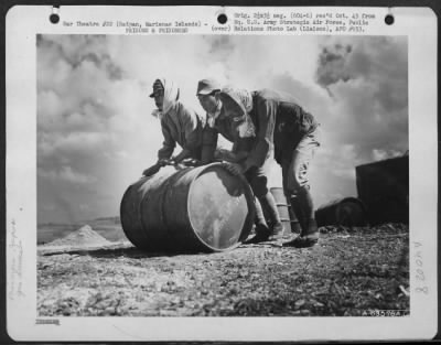 Consolidated > Japanese Soliders And Civilian Prisoners Of War Rolling And Stacking Gasoline Drums At A Supply Dump On Saipan, Marianas Islands.  29 June 1944.