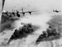 B-24s fly though flak, over destruction created by preceding waves of bombers.jpg