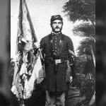 Wm Irvine holding tattered regimental flag from Gettysburg.jpg